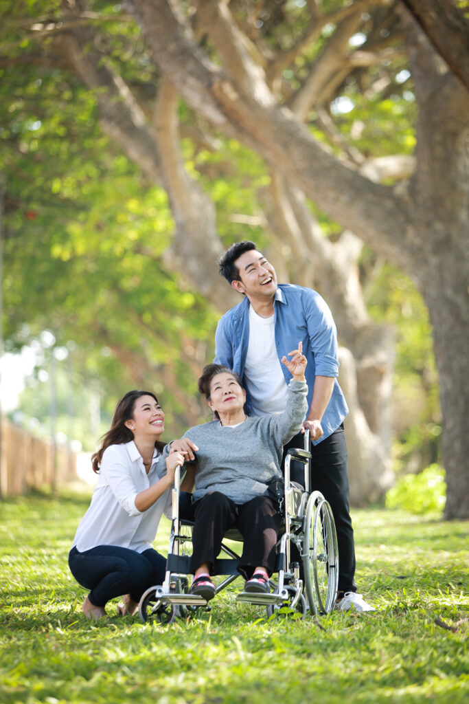 Asian senior woman sitting on the wheelchair with family happy s
